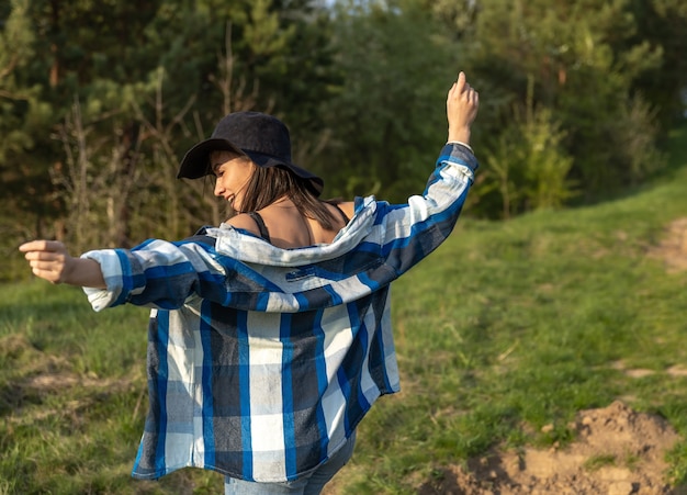 Jolie fille lors d'une promenade dans la forêt de printemps dans un style décontracté