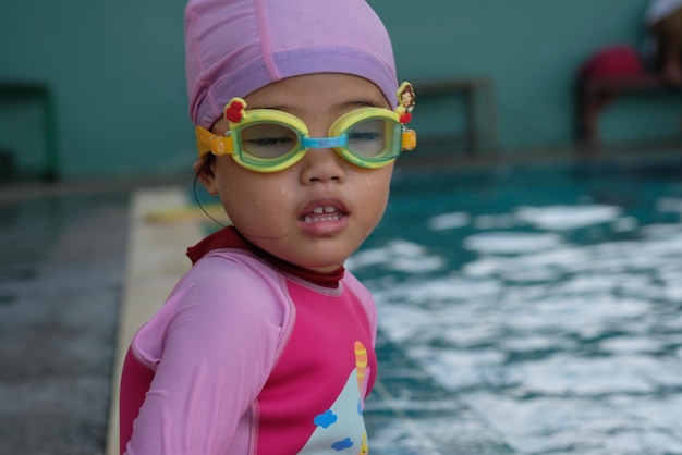 Photo une jolie fille avec des lunettes de natation près de la piscine