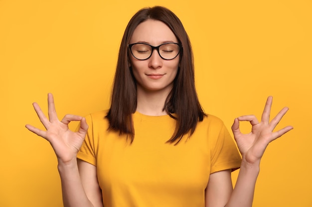 Jolie fille à lunettes se sent détendue, joyeuse et calme