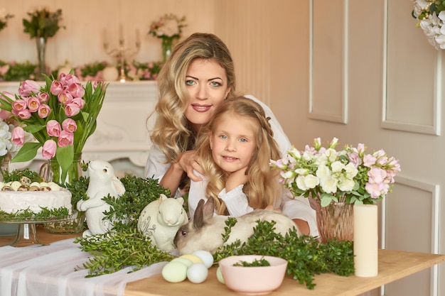 Jolie fille et mère jouant avec le lapin