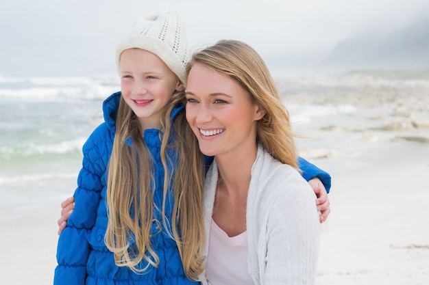 Jolie fille avec une mère souriante sur la plage