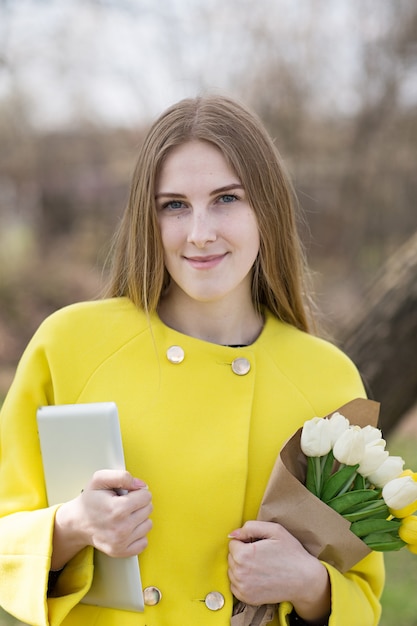 Jolie fille mignonne aux cheveux longs dans un manteau jaune.