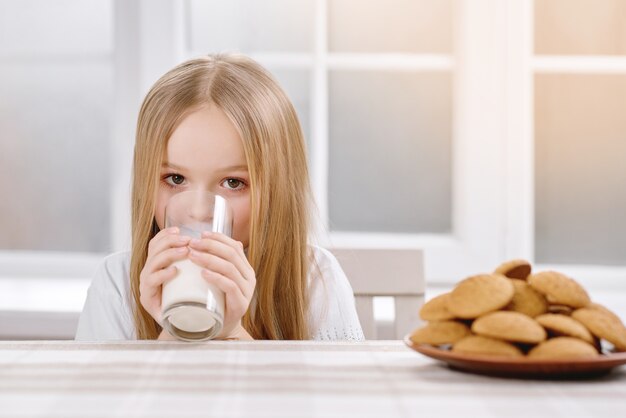 Jolie fille mignonne boit du lait.