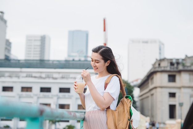 Jolie fille mignonne à la mode, boire du café à l'extérieur.