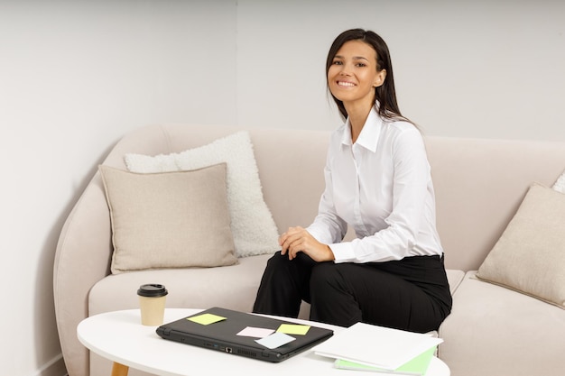 Une jolie fille avec un ordinateur portable à une table basse