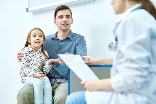 Jolie fille avec papa en visite chez le médecin