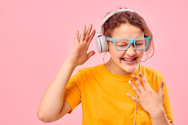 Jolie fille portant des lunettes bleues écoutant de la musique sur un casque vue recadrée inchangée