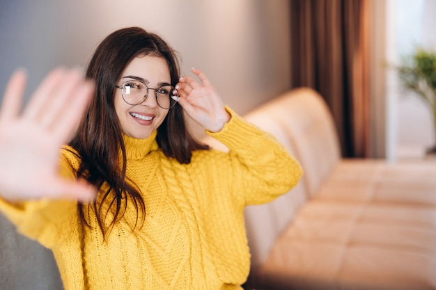 Jolie fille portant des lunettes et un joli pull travaille en freelance à la maison