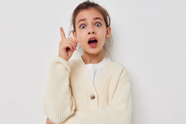 Jolie fille posant dans un pull blanc fond isolé