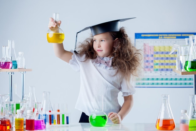 Une jolie fille posant avec des tubes à essai colorés dans le laboratoire