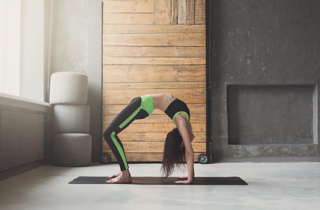 Jolie fille pratiquant le yoga. Jeune femme faisant une pose de dessus de table sur un tapis à l'intérieur du club de sport, espace de copie