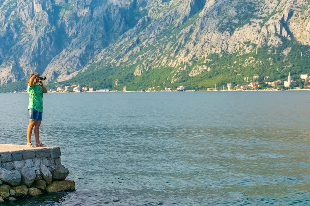 Une jolie fille prend des photos du paysage marin