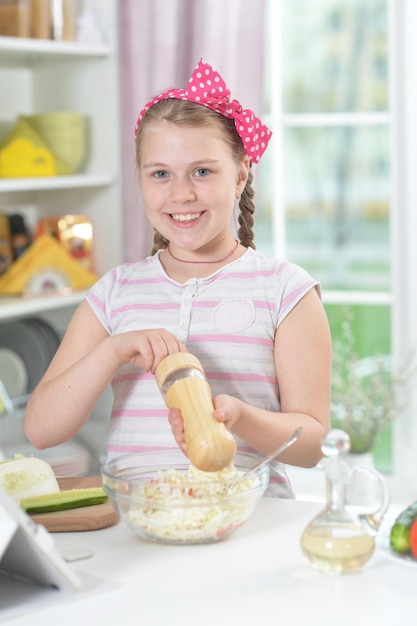 Jolie fille préparant une délicieuse salade fraîche