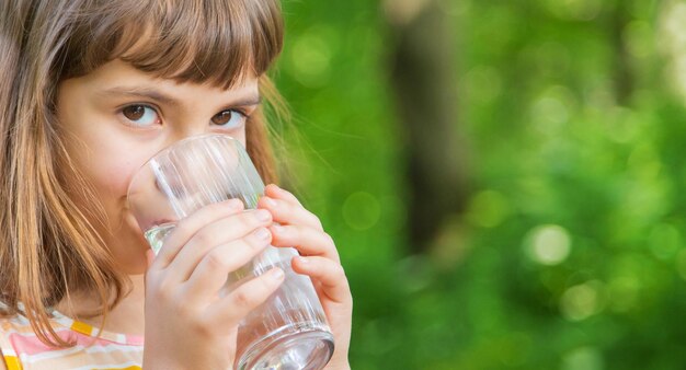 Photo une jolie fille qui boit de l'eau sur la route.