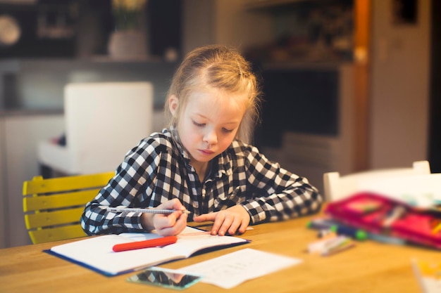 Une jolie fille qui étudie à table.