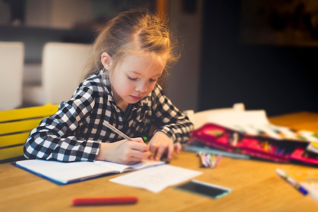 Une jolie fille qui étudie à table.