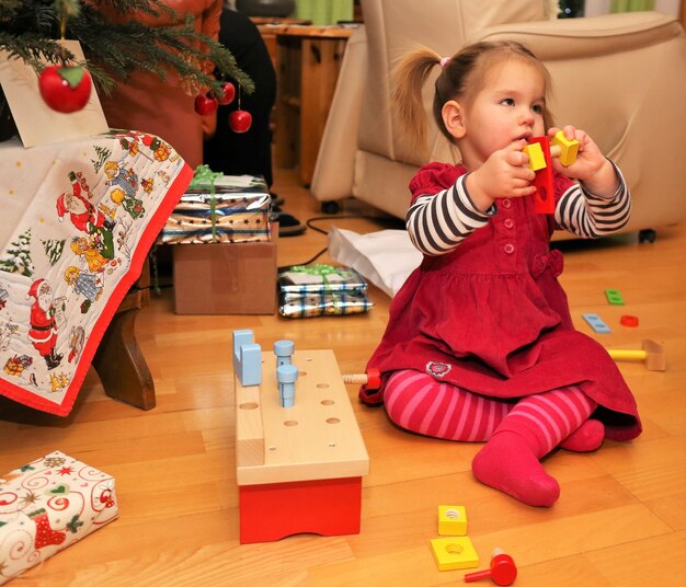 Photo une jolie fille qui joue avec des jouets à la maison.