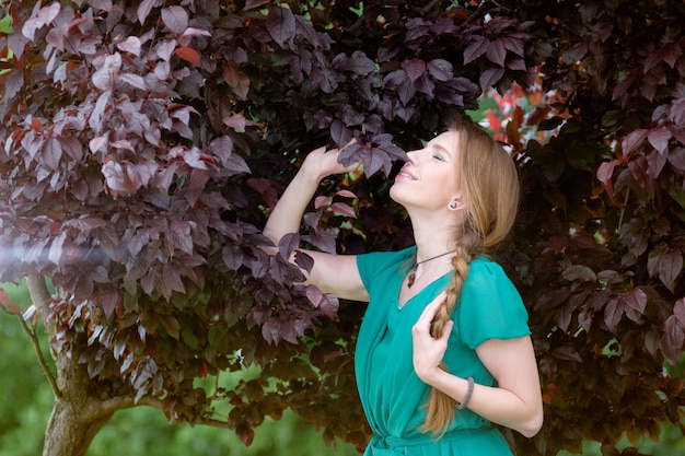 Jolie fille rousse en portrait de feuilles violettes ou brunes