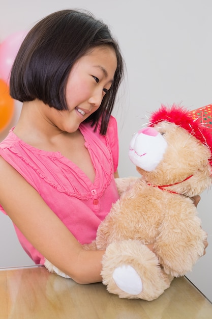 Jolie fille avec sa peluche à une fête d&#39;anniversaire