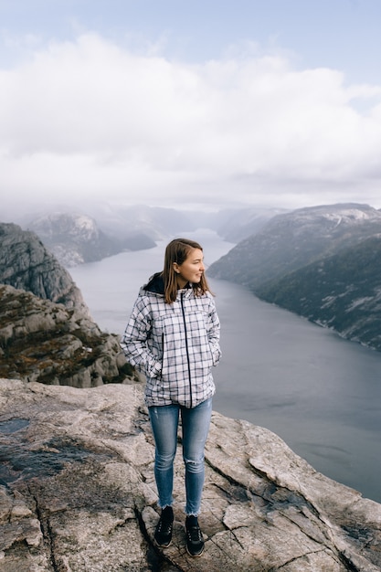 Une jolie fille se dresse au sommet du mont Preikestolen (Pulpit Rock) en Norvège