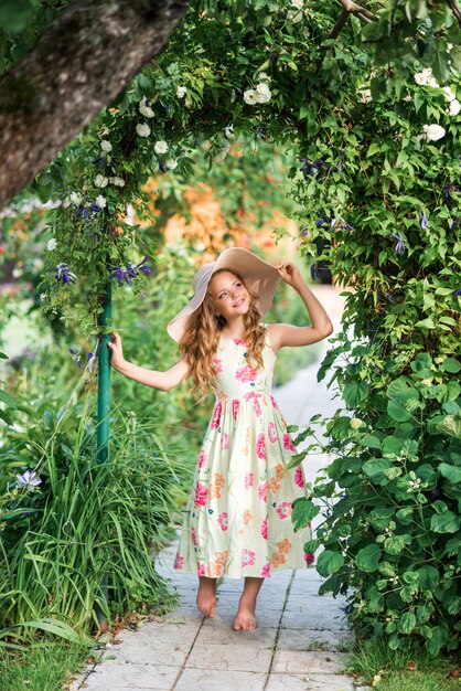 Jolie fille se promène dans le jardin d'été