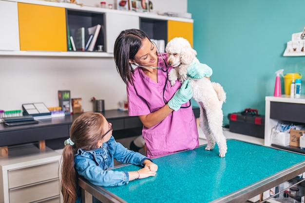 Jolie fille avec son chien chez le vétérinaire.