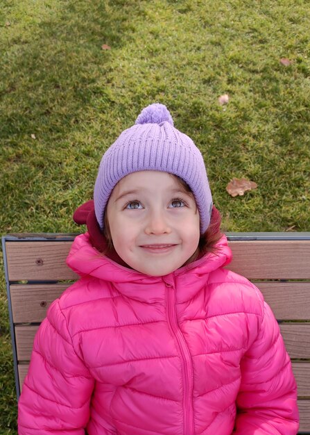 Jolie fille souriante assise sur le banc