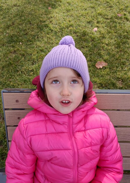 Jolie fille souriante assise sur le banc