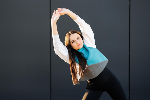 Jolie fille sportive faisant des étirements dans la rue avant l'entraînement