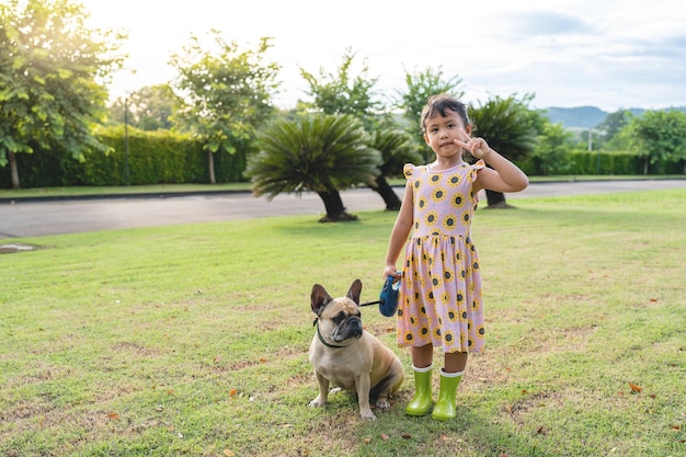 Jolie fille tenant une laisse de chien sur le terrain.