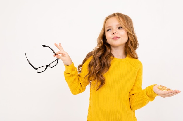 Jolie fille tenant des lunettes et des boules de cristal dans ses mains similaires à des lentilles