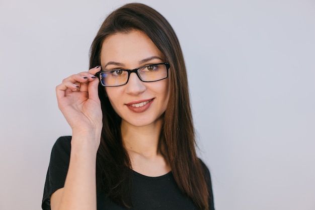 Une jolie fille touche une jante par des lunettes avec ses doigts.