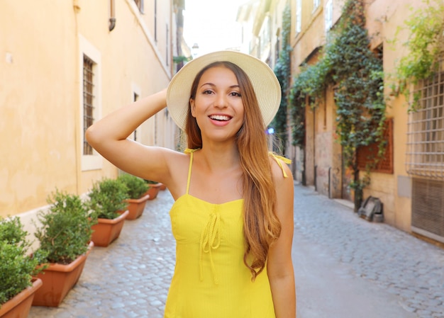Jolie fille à Trastevere, Rome. Belle femme de mode avec une robe jaune et un chapeau se promène dans les rues de Rome, Italie.
