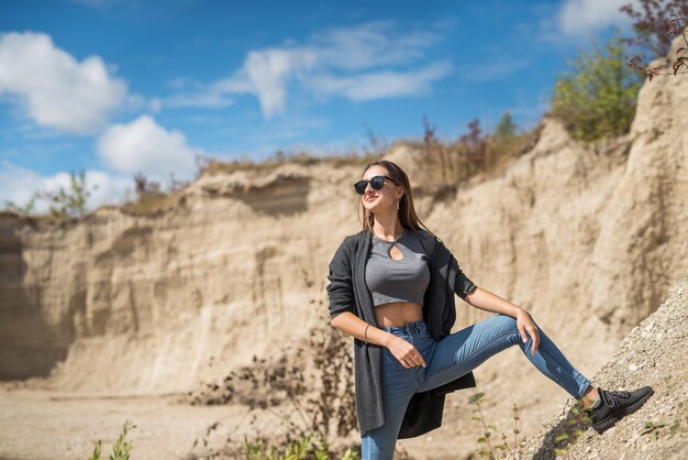 Jolie fille vêtue d'un chiffon décontracté se promène parmi les sables du désert, l'été parfait pour le voyage