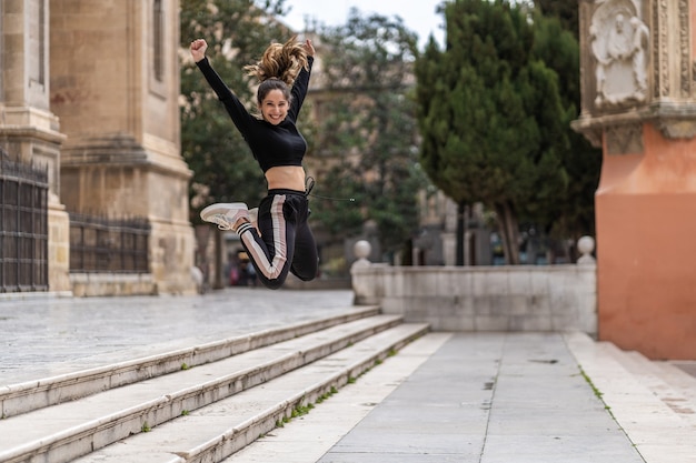Jolie et heureuse jeune femme caucasienne sautant pour le bonheur