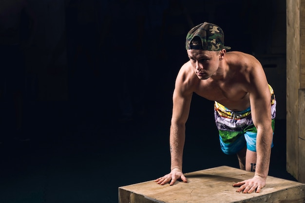 Jolie homme fatigué après l'haltérophilie au gymnase