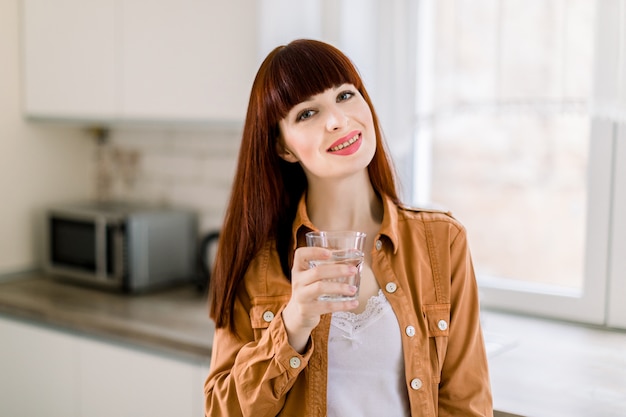 Jolie jeune belle femme aux cheveux rouges en chemise moutarde décontractée