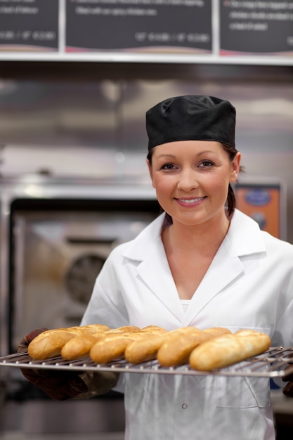 Jolie jeune boulanger avec des baguettes