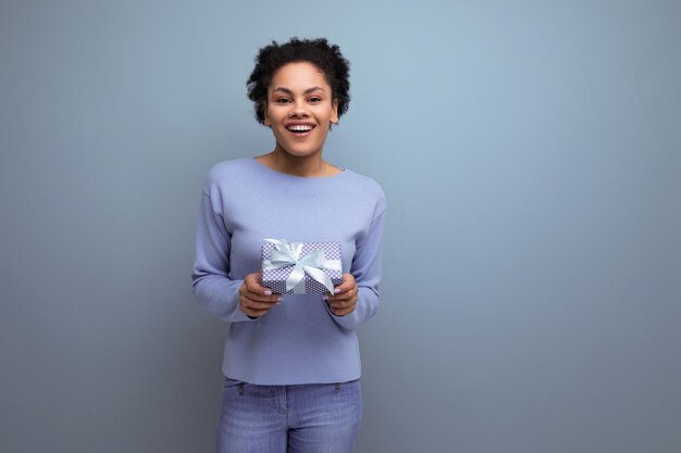 une jolie jeune dame brune latine avec une boîte cadeau avec un nœud