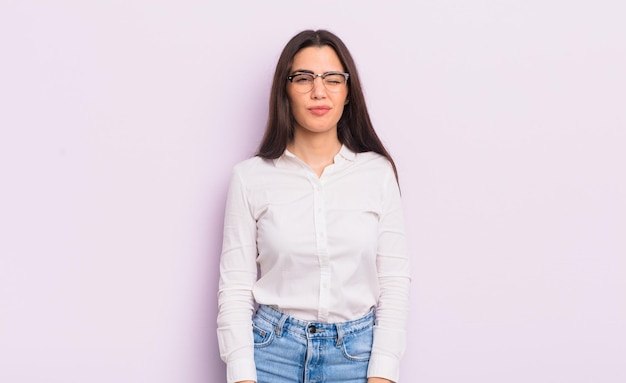 Jolie jeune femme à l'air heureuse et amicale souriante et vous faisant un clin d'œil avec une attitude positive