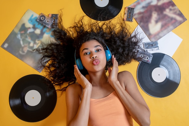 Jolie jeune femme allongée sur le sol et écouter de la musique