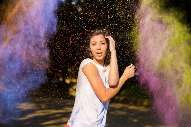 Jolie jeune femme asiatique aux cheveux longs jouant avec de la poudre Holi