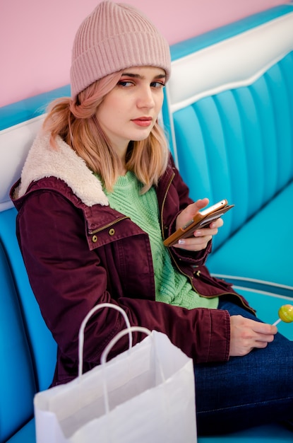 Jolie jeune femme assise dans un café après le shopping