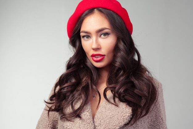 Photo jolie jeune femme au béret rouge et manteau à la mode