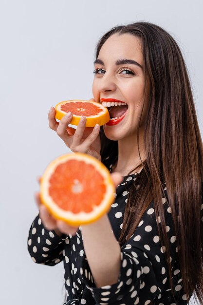 Jolie jeune femme aux agrumes. Belle femme posant pour la caméra avec orange.