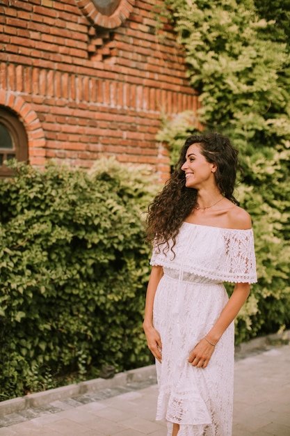 Jolie jeune femme aux cheveux bouclés dans le parc