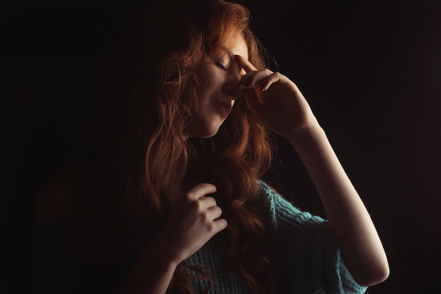 Jolie jeune femme aux cheveux longs dans l'ombre