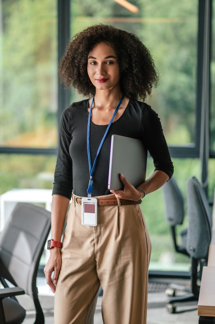 Photo jolie jeune femme aux cheveux noirs avec un alptop au bureau