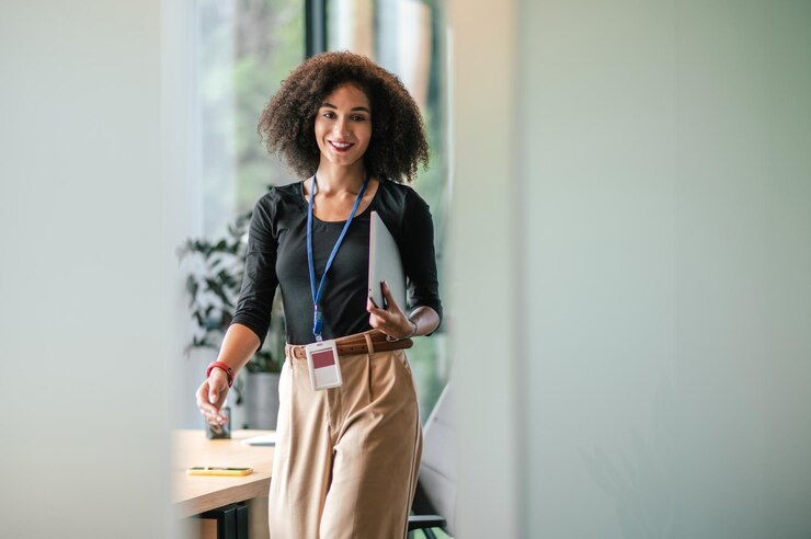Photo jolie jeune femme aux cheveux noirs avec un alptop au bureau