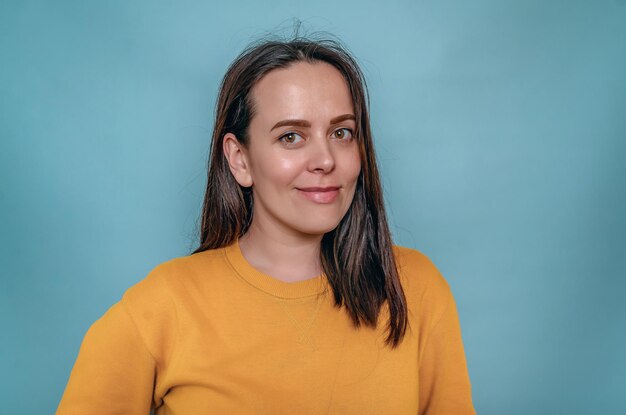 Photo jolie jeune femme aux cheveux noirs et aux yeux bruns sourit à la caméra